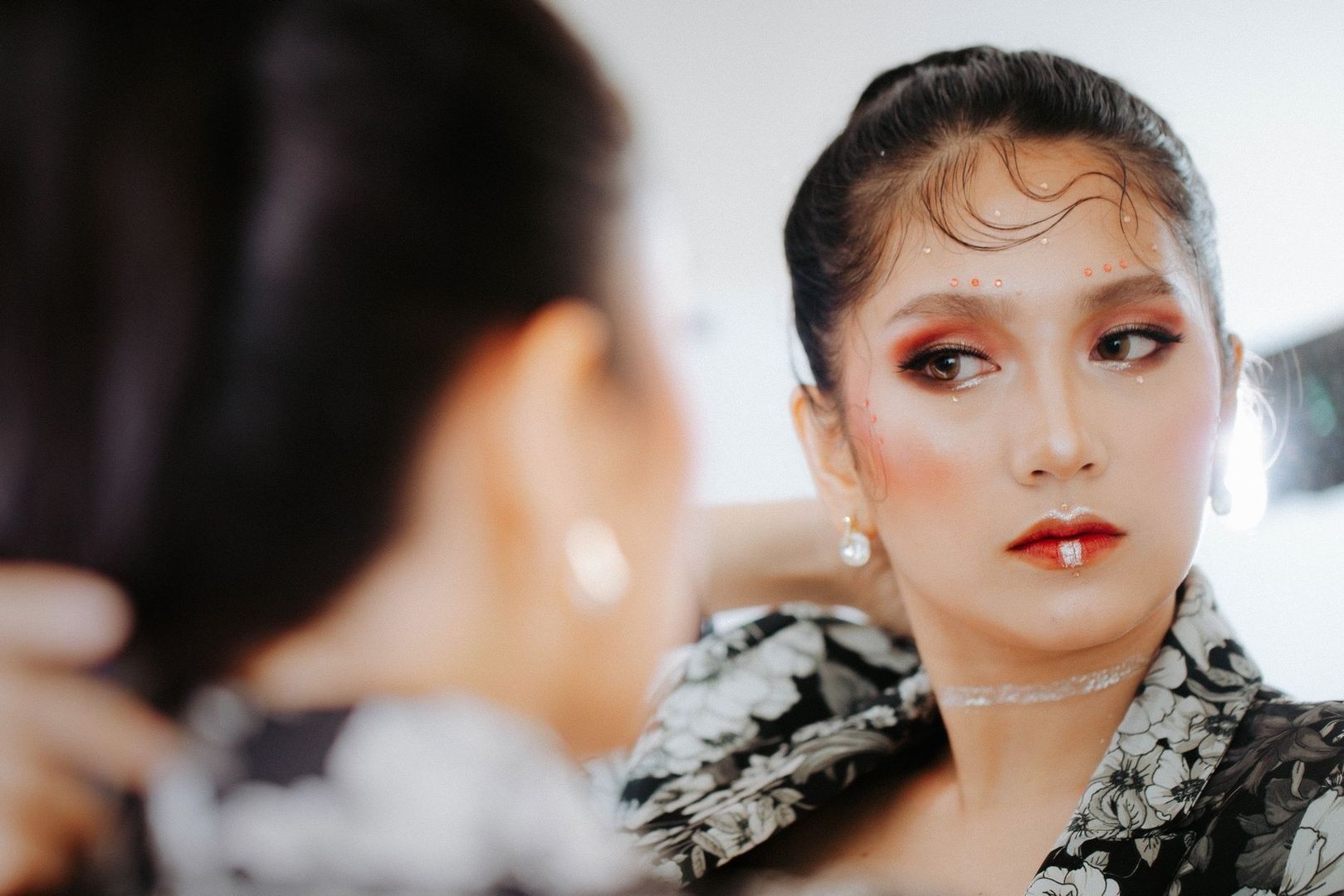 Person med skimrande makeup och krämiga färgtoner i ansiktet