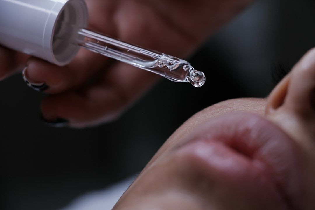Glasdropper med serum hålls nära huden under ögat