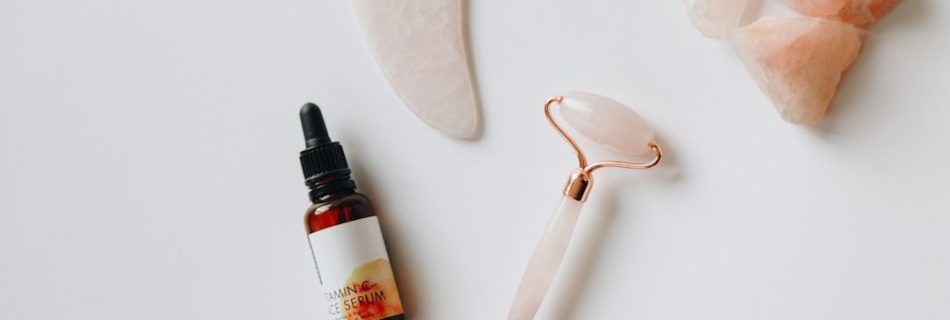 Hudvårdsprodukter med ansiktsroller, serum och gua sha-sten i rosenkvarts.