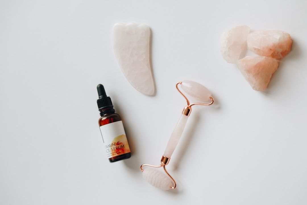 Hudvårdsprodukter med ansiktsroller, serum och gua sha-sten i rosenkvarts.